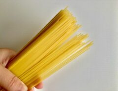 パスタの麺を手でつかんでいる様子