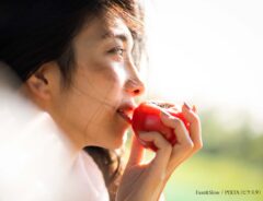 トマトを食べる女性の写真