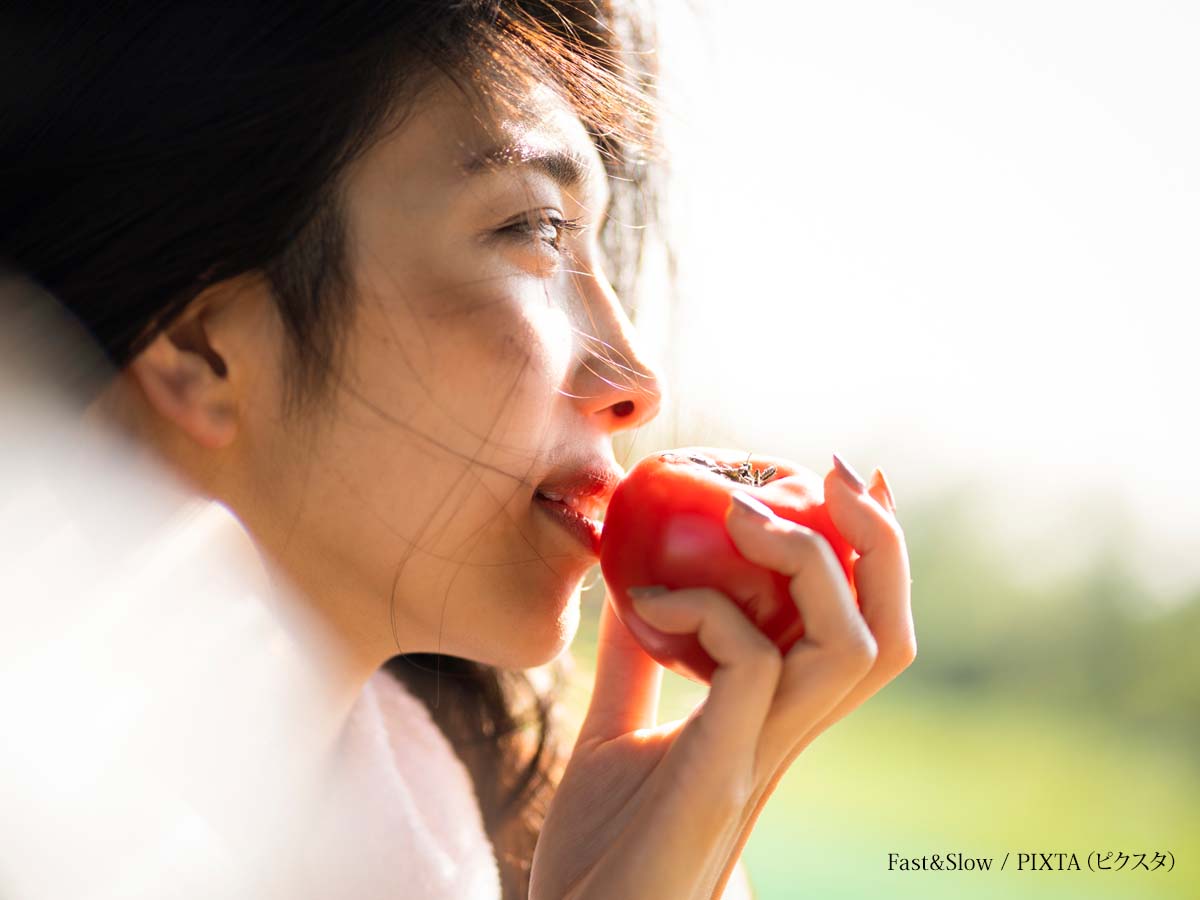 トマトを食べる女性の写真