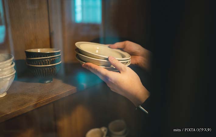 食器を手に取る女性の手の写真