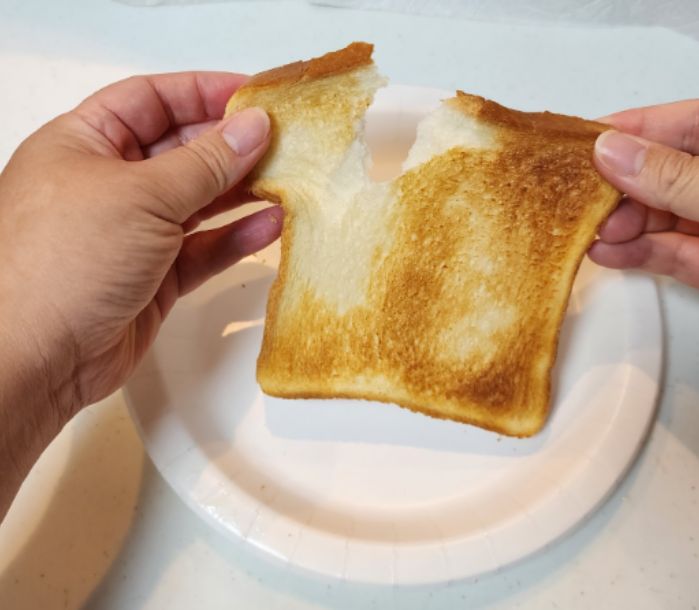 焼きあがった食パンを皿の上で割く様子