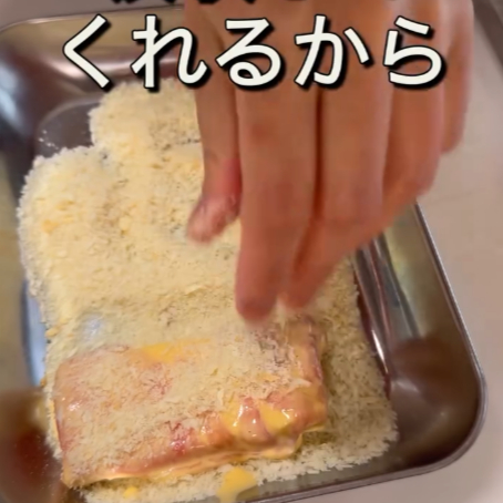 バッター液を付けた厚揚げ豆腐にパン粉を付ける様子