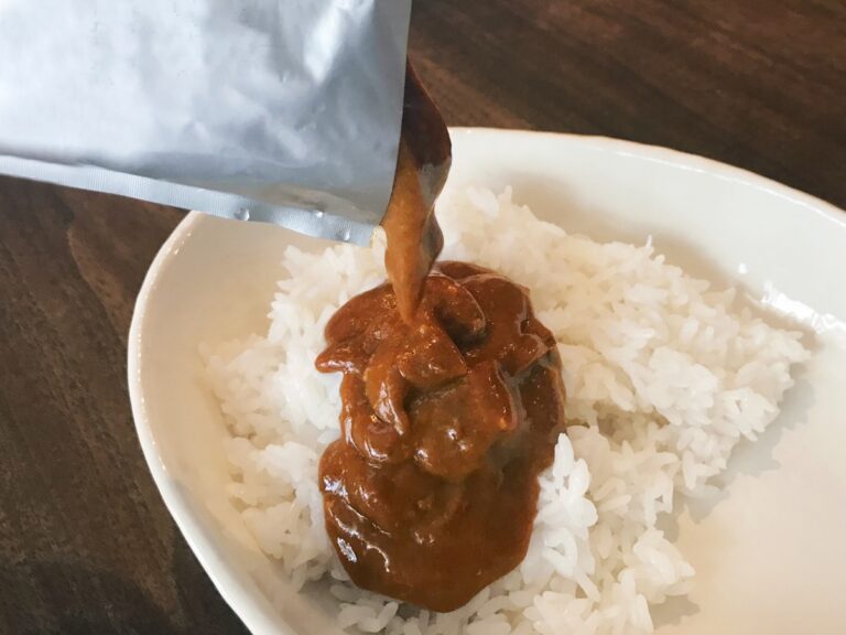 レトルトカレーをごはんにかけている様子