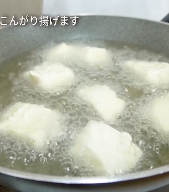 片栗粉をまぶした豆腐を油で揚げる様子