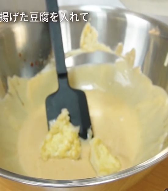 揚げた豆腐を調味料を合わせたボウルに入れた様子