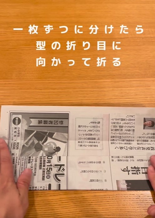 折り目を付けたら調味料スペースから取り出して新聞紙を１枚ずつに分けます。