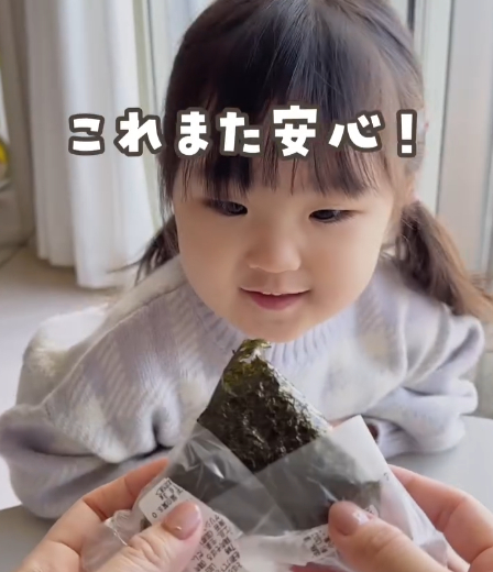 フィルムを外したおにぎりを子どもが見つめる様子