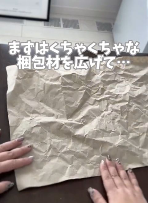 くしゃくしゃになった緩衝材を広げて伸ばす様子