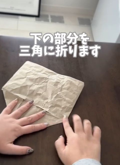 下の部分を三角に折る様子