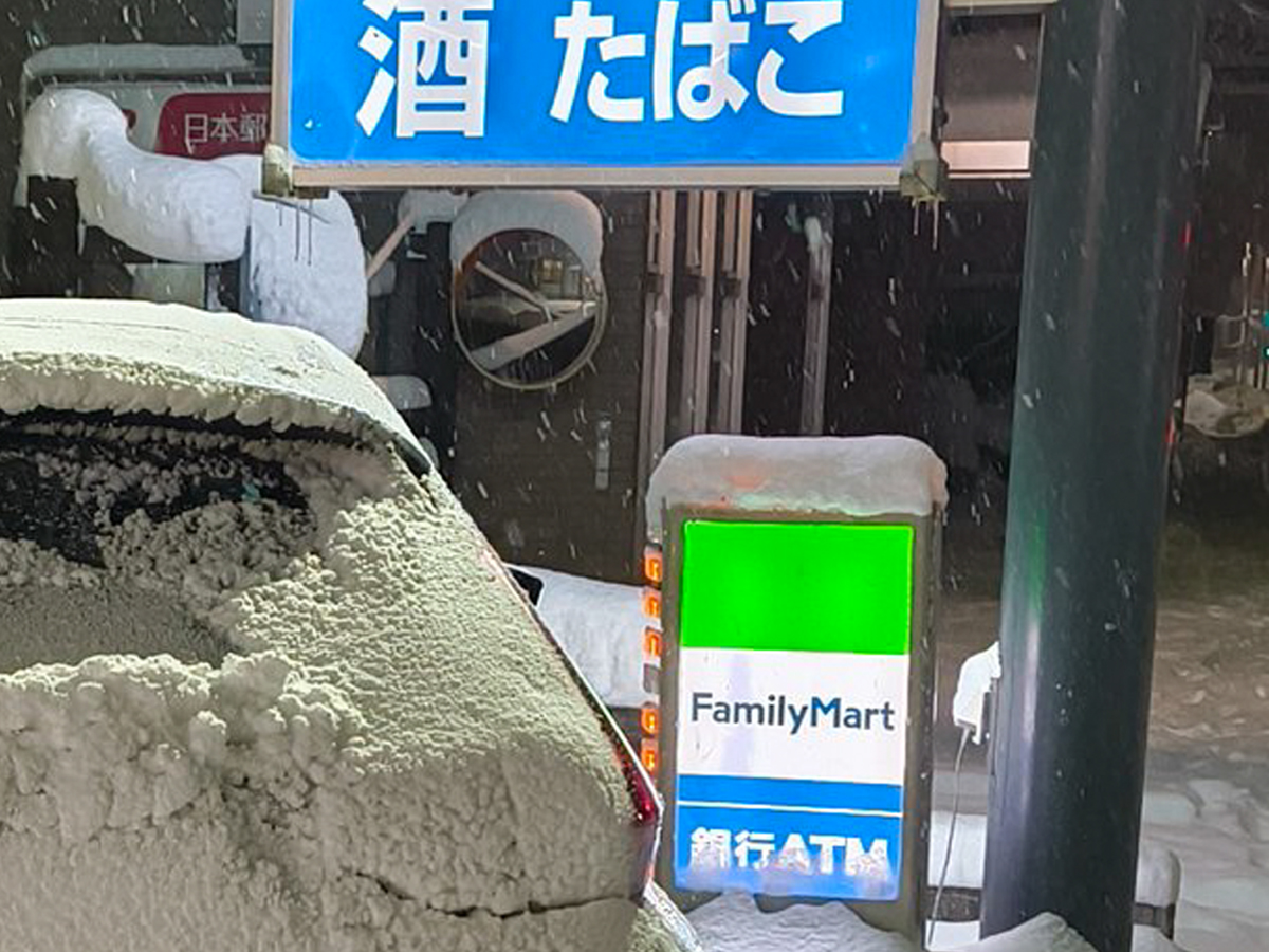 雪が積もったコンビニの駐車場の写真