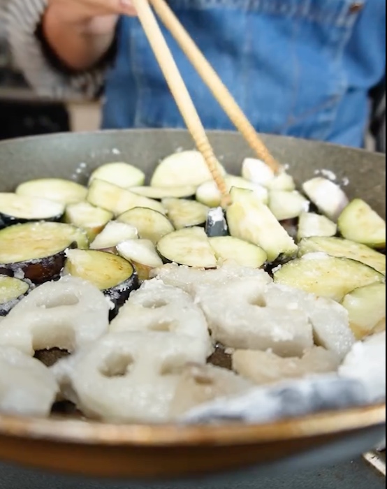 ナスとレンコンを揚げ焼きしている様子