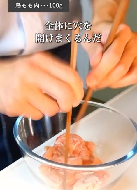 ボウルに入れた鶏もも肉に箸で穴を開ける様子