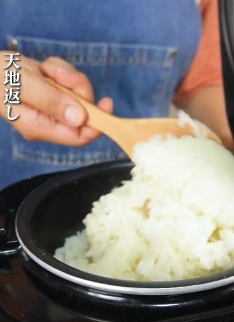 炊きあがったご飯をしゃもじで底からすくうように混ぜる様子