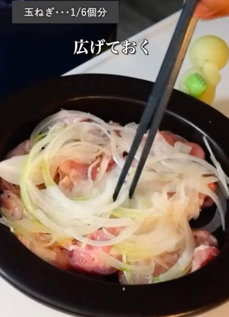 スライスしたタマネギを鶏肉の上に広げる様子