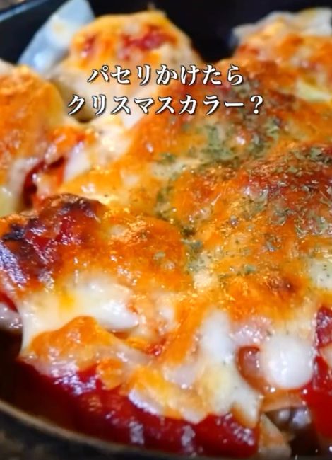 焼きあがったチキンのチーズ焼きにパセリをかける様子