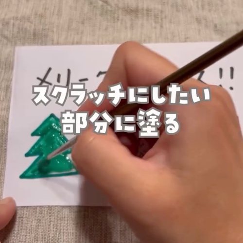 メッセージに筆で絵の具をのせている様子