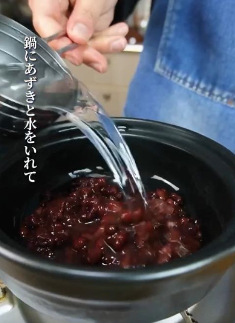 ゆで小豆を入れた鍋に水を入れる様子