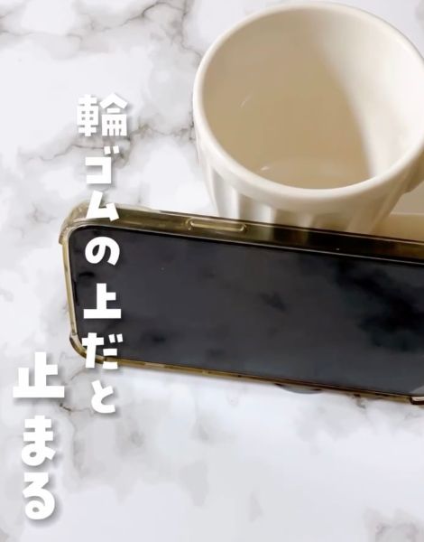 輪ゴムの上にスマートフォンを置いて湯呑にたてかけた様子