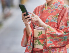 着物の女性がスマホを使う写真