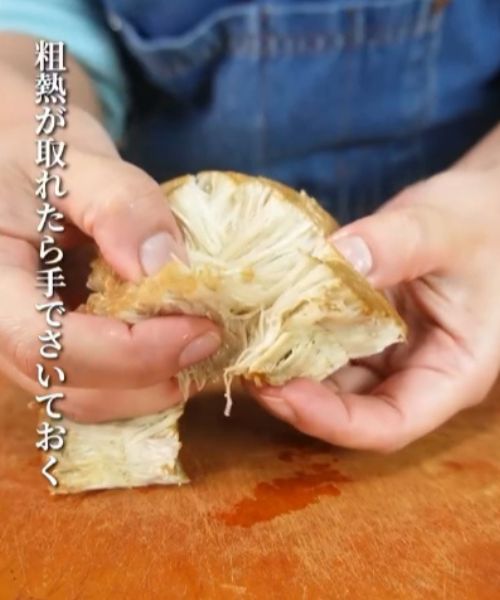 焼き目を付けたエノキを手でほぐす様子