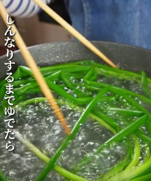 菜箸で混ぜながら青ネギをゆでる様子