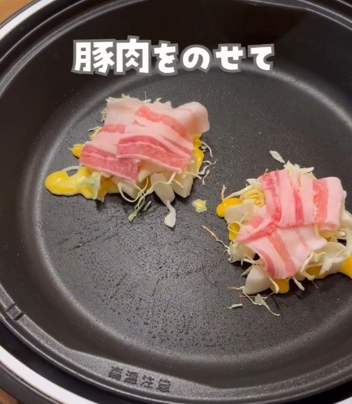 餅の上にキャベツと溶き卵、豚肉をのせた写真