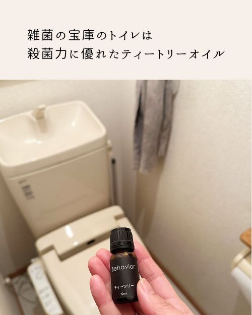 トイレでティーツリーの精油ボトルを手に持っている様子