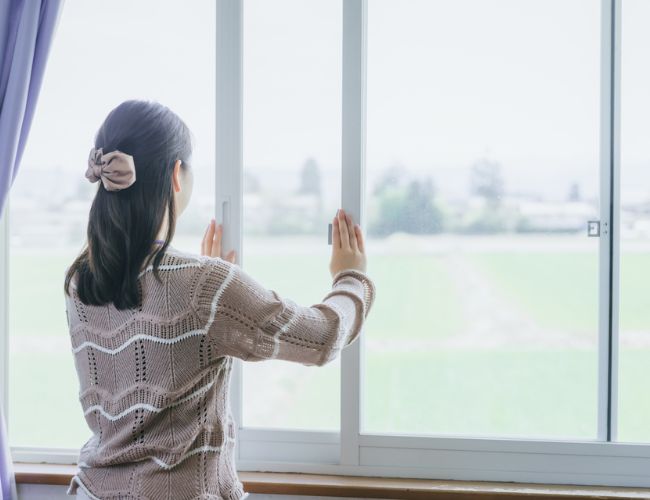 女性が窓を開ける様子