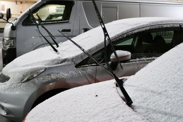 車のワイパーを立てて降雪対策をしている車の写真