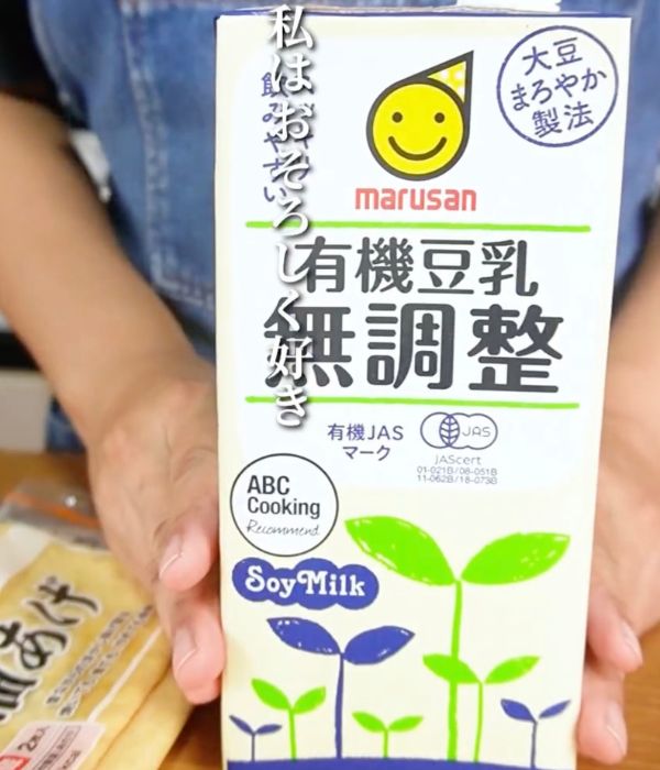 『無調整豆乳』のパッケージをカメラに向かって見せている写真