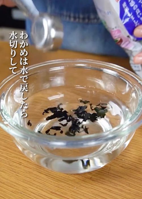 水を張ったボウルに乾燥ワカメを入れて戻す様子