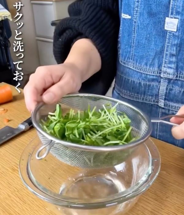 洗った豆苗をザルに入れて水を切る様子