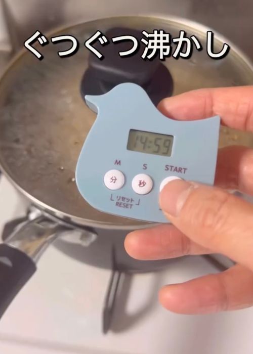 鍋に蓋をしてキッチンタイマーで時間を計る様子