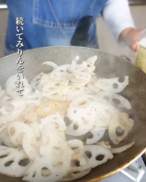 レンコンを炒めるフライパンにみりんを入れる様子