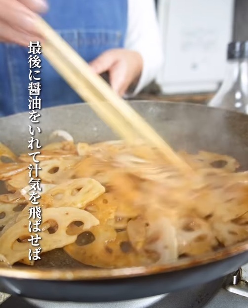 レンコンを炒めるフライパンに醤油を回しかける様子