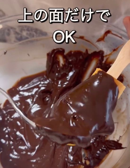 焼き上がったスティックパンの表面にチョコレートソースを付ける様子