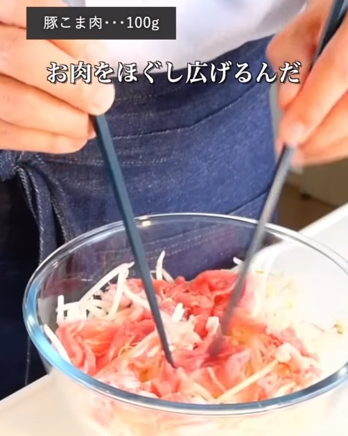 モヤシの上に豚肉をのせる様子