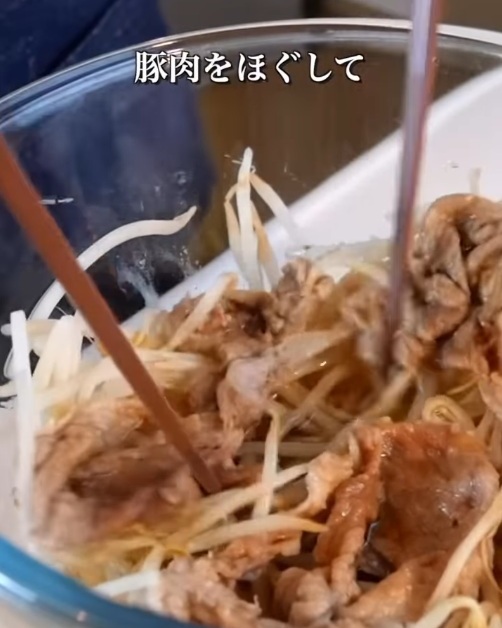 ボウルの中の豚肉をほぐす様子