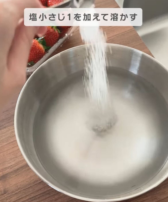 ボウルに入った水に塩を入れる様子