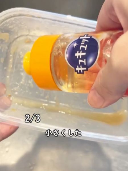 汚れの付いた保存容器に食器用洗剤を入れる様子