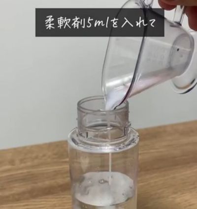 水の入ったボトルに柔軟剤を入れている様子