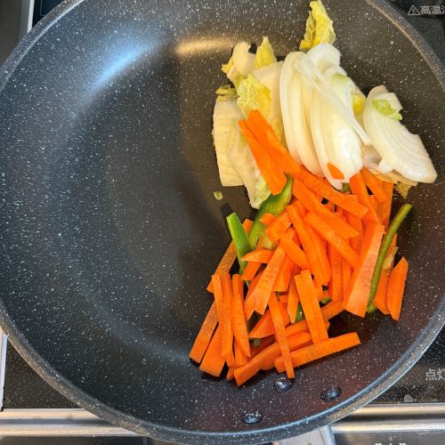 フライパンの右半分に野菜炒めの野菜を入れた様子