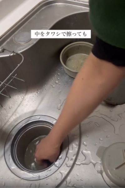 排水口の奥をタワシでこする様子