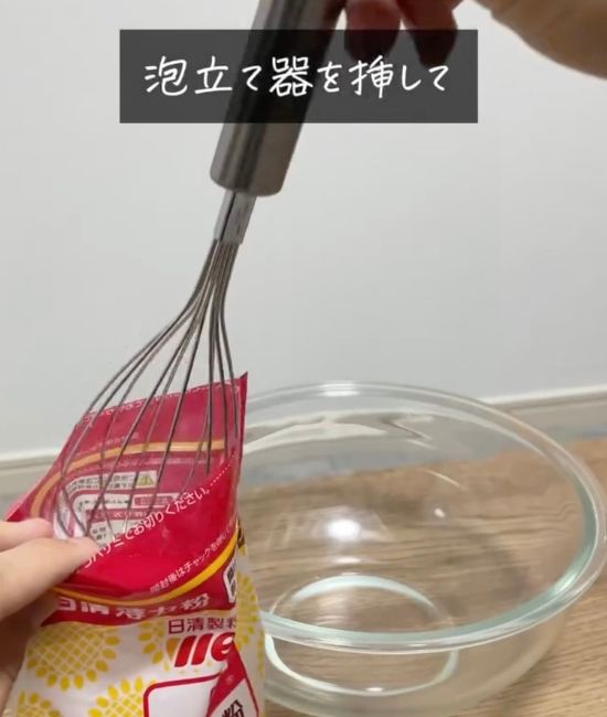 小麦粉の袋に泡立て器を突き刺すように入れる様子