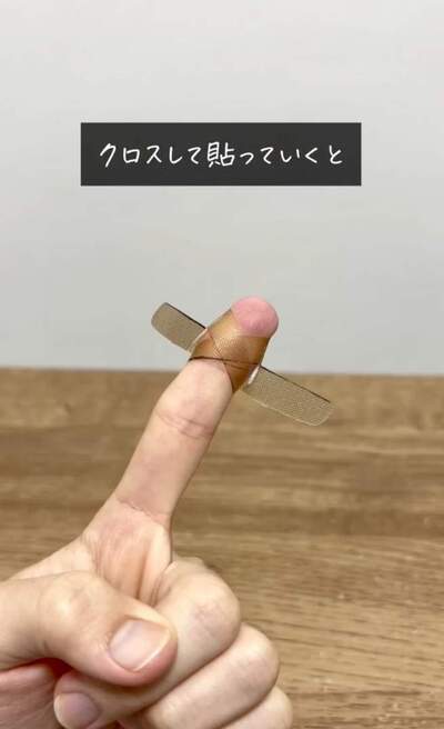 切り込みを入れた絆創膏をクロスしながら貼る様子