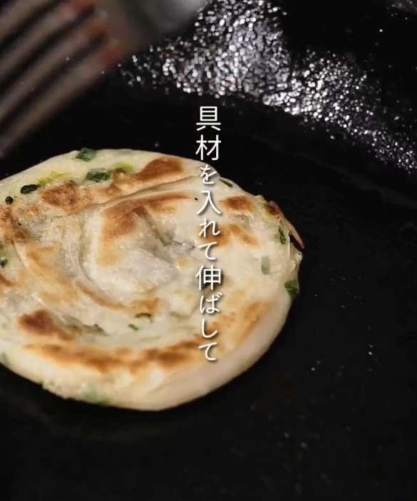 フライパンで具材の入った餃子の皮を焼く様子