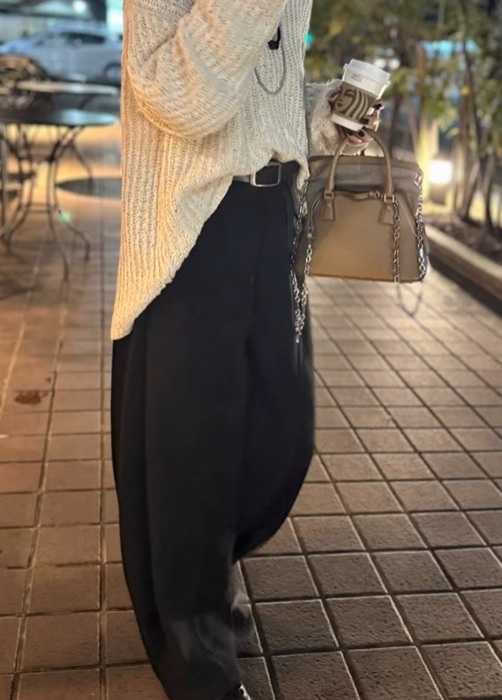 ワイドカーブパンツと白のトップスを着る女性
