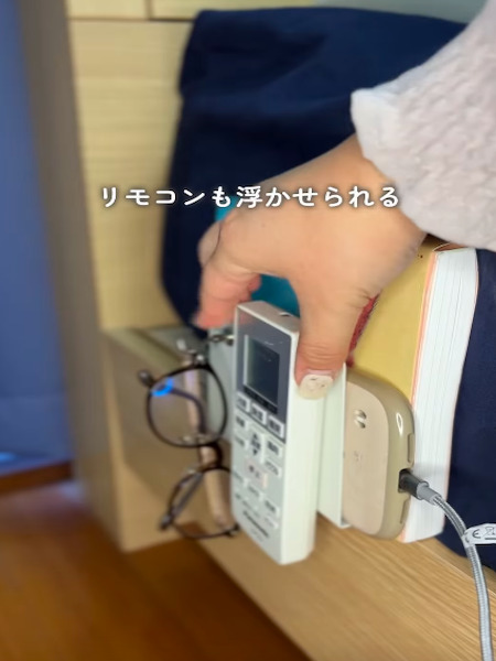 ベッドとマットレスの間に挟んだブックエンドに『マグネットテープ』を貼り付けたリモコンをくっつけた様子