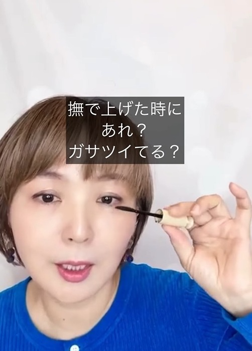 マスカラを手にした女性とキャプション
