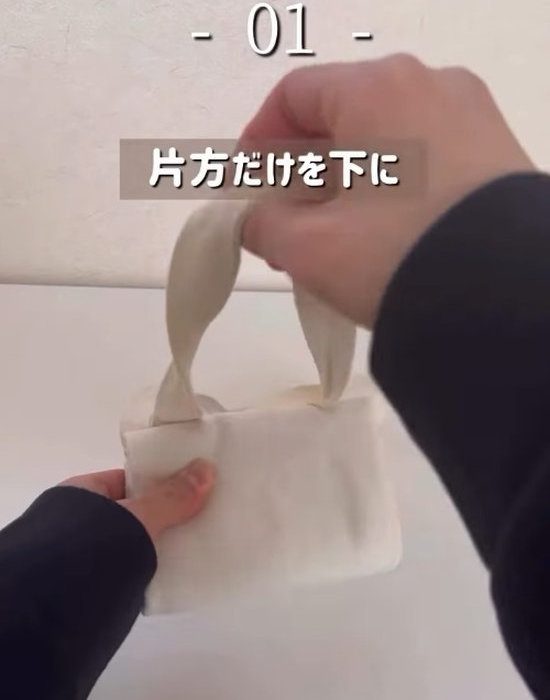 半分に折ったエコバッグを下からさらに折りたたんでいく様子